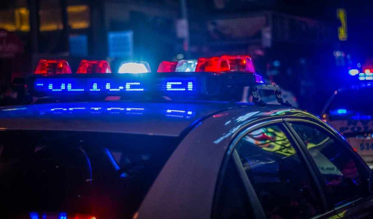 Polizeiauto mit eingeschaltetem Blaulicht in einer nächtlichen Strasse