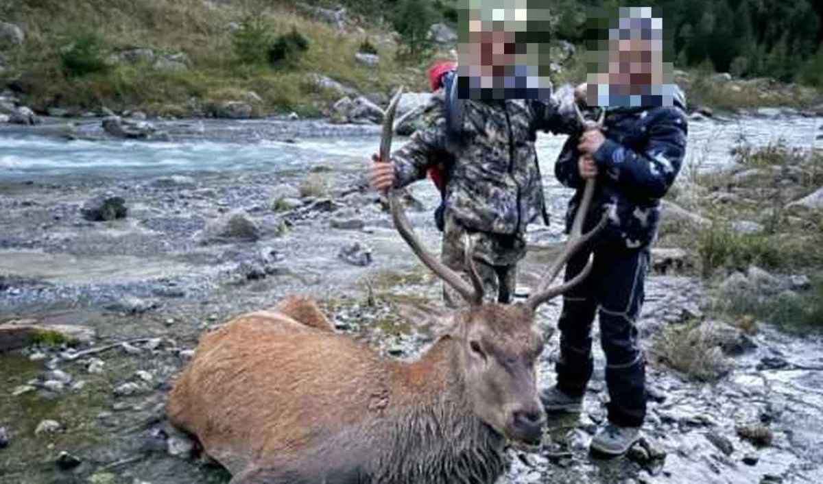 Doi copii țin coarnele unui cerb împușcat, chipurile fiind făcute neidentificabile de către redacție; fotografie din galeria RTR pentru concursul La Preda